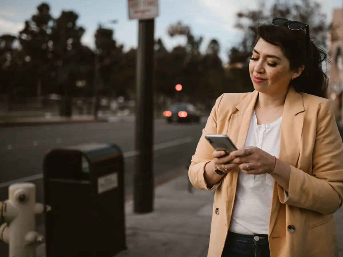 A woman checking her phone on a city street